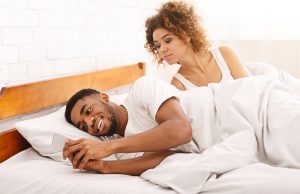 Cheating african man chatting with mistriss in family bed